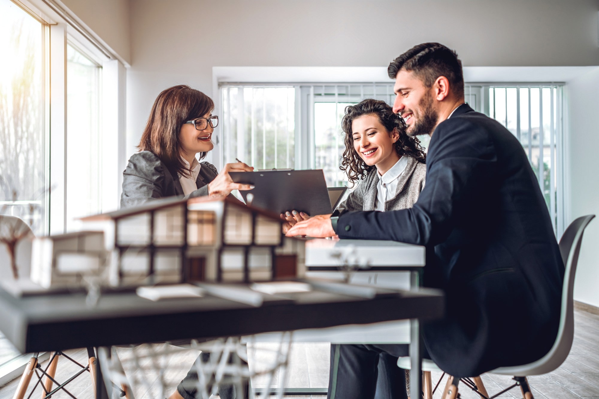 Side view image of young happy family sitting in consulting office